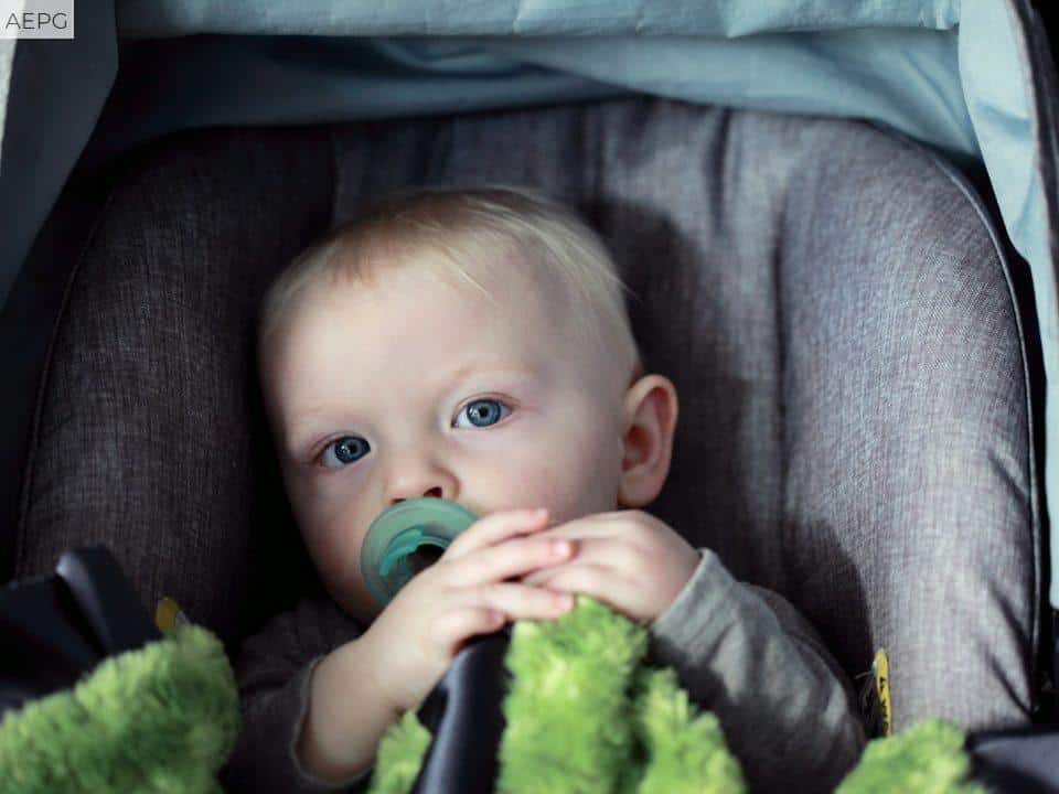baby on gray stroller