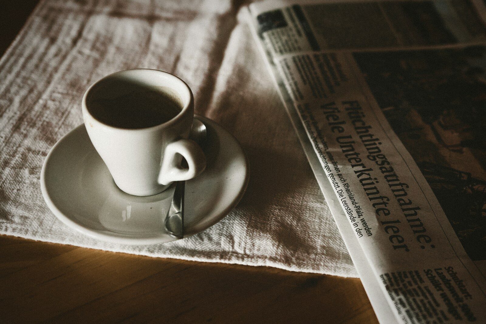 Taza de café junto a un periódico doblado: leer periódicos gratis cada mañana
