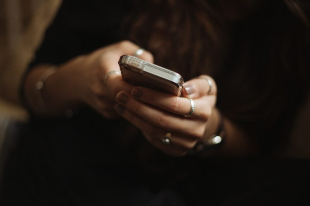 Manos sosteniendo un móvil para leer prensa digital